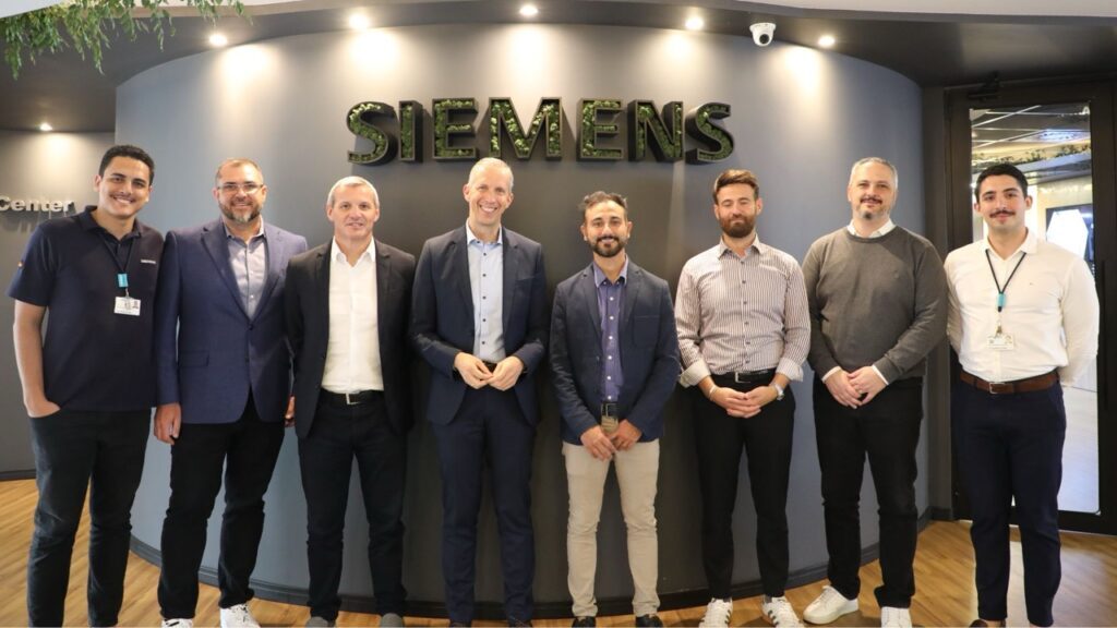 Pablo Fava e Rainer Brehm posando com a equipe da Siemens Brasil em São Paulo