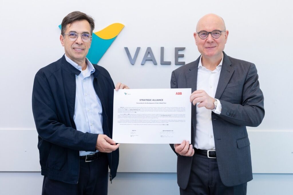 Carlos Medeiros, da Vale, e Joachim Braun, da ABB, sentados a uma mesa assinando o acordo de ampliação da parceria